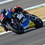 Dynamic capture of a motorcycle racing on an outdoor track with rider in sportswear.