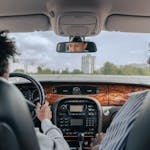 Father and son bonding while driving, showcasing guidance and togetherness in a car's interior.