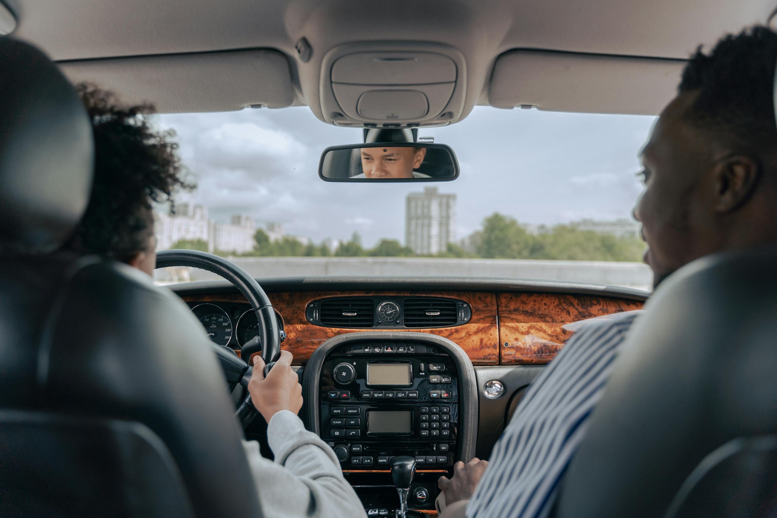 Father and son bonding while driving, showcasing guidance and togetherness in a car's interior.