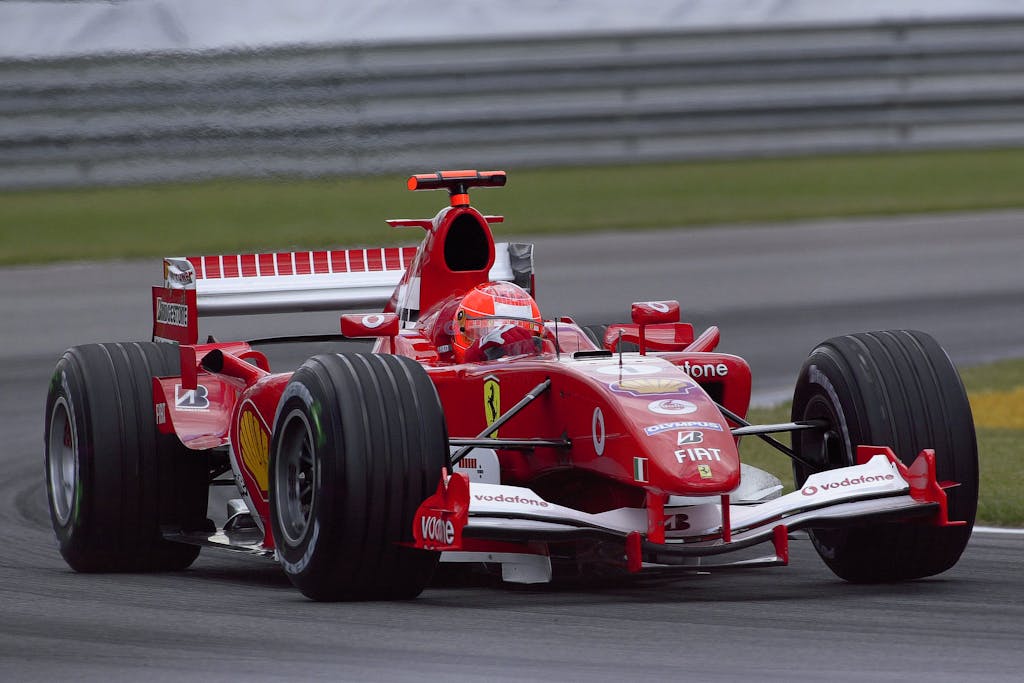 Ferrari Formula 1 car racing at high speed on the Indianapolis track, showcasing motorsport excitement.